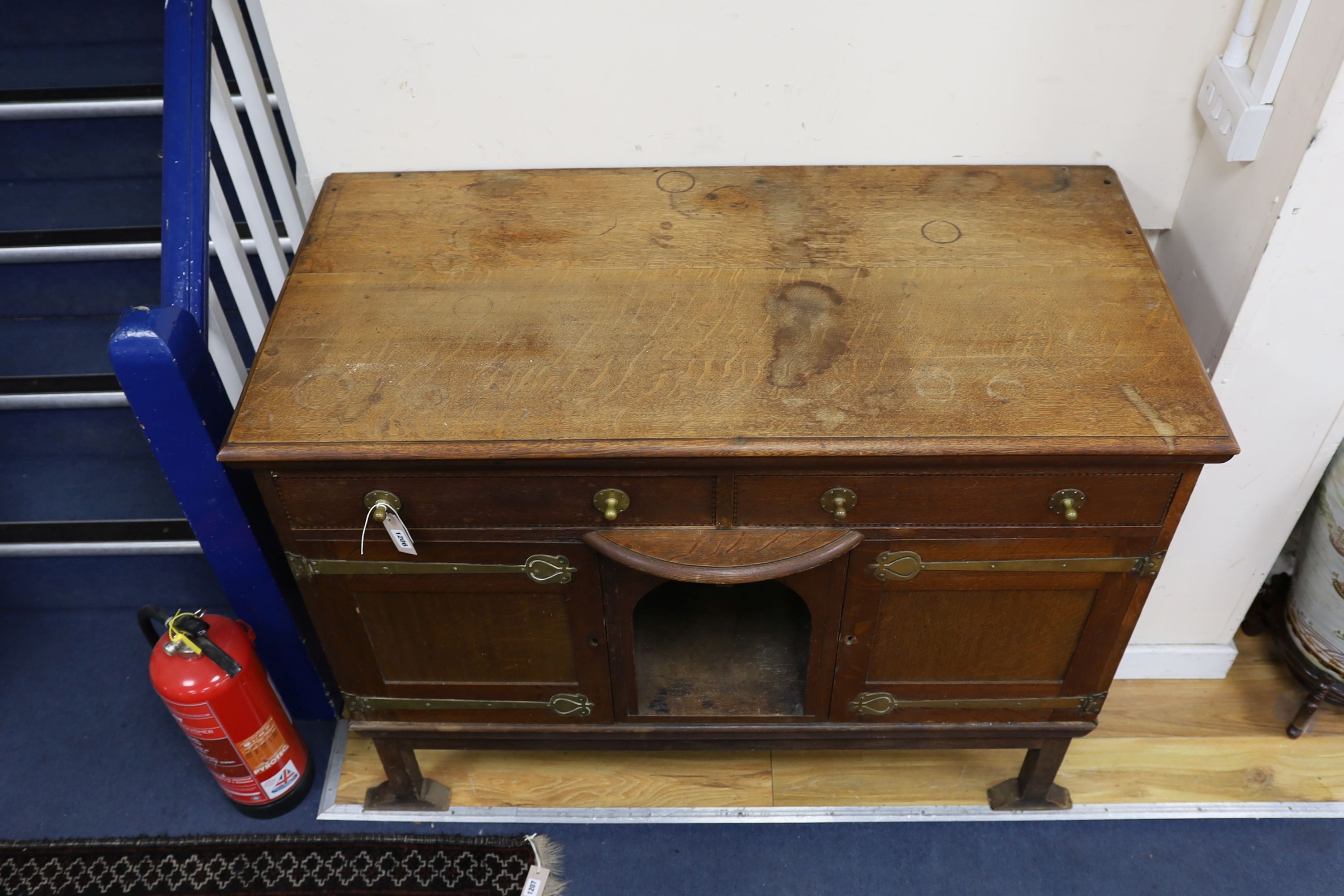 An Art Nouveau brass mounted oak buffet in the style of Voysey, length 124cm, depth 60cm, height 99cm